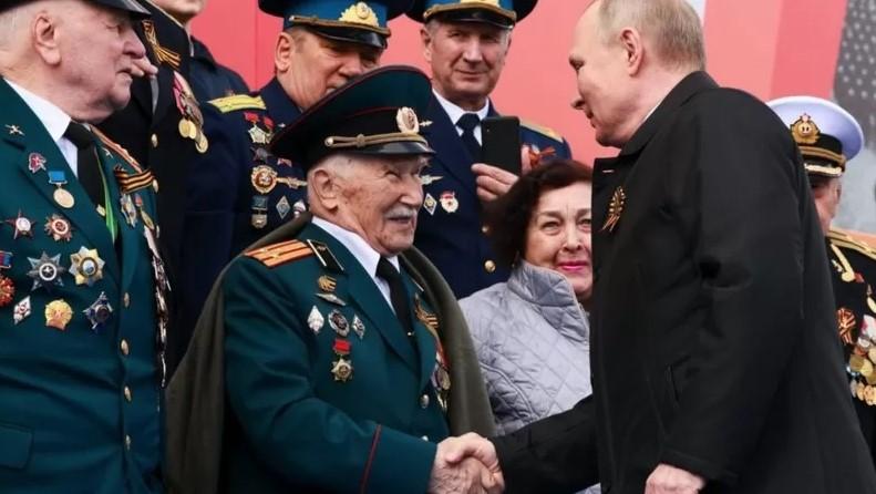 На фото Путин поздравляет ветеранов ВОВ на параде 9 мая.