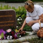 На фото жительница Донецка возлагает цветы на алею Ангелов в память погибшим детям Донбасса.