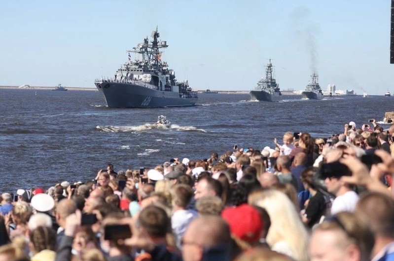 На фото люди смотрят парад боевых кораблей во время празднования ВМФ-военно-морского флота в России.