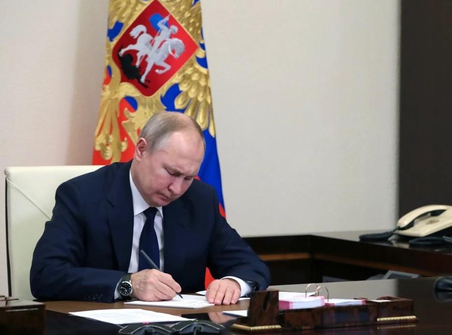 На фото президент Путин подписывает благодарственные письма заслуженным гражданам России.
