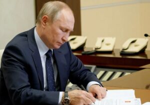 На фото Путин подписывает указы и распоряжения.