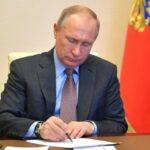 На фото Путин подписывает указы.