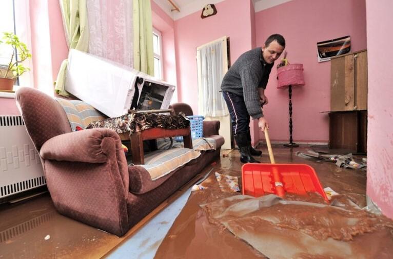 На фото хозяин квартиры убирает последствия затопления.
