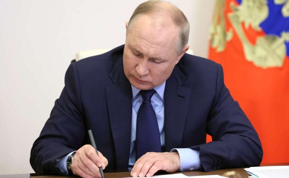 На фото Путин подписывает документы.