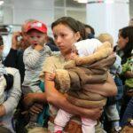 На фото беженцы с Украины женщины с детьми на руках.