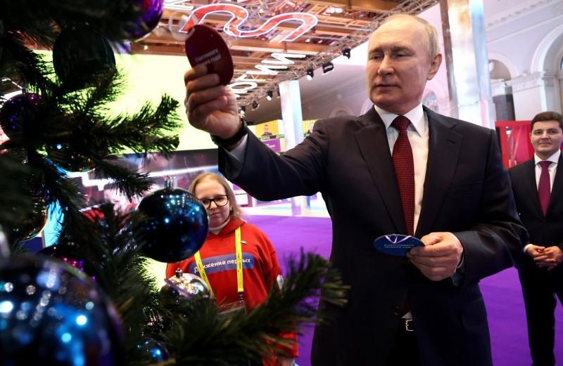 На фото Путин снимает с ёлки желаний жетон для подарка ребёнку на Новый Год.
