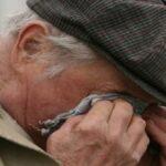 На фото оскорблённый пенсионер вытирает слёзы.